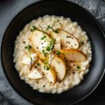 Risotto cremoso con taleggio e pere servito in piatto nero moderno – ricetta riso taleggio e pere