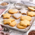 Biscotti di pasta frolla fatti in casa appena sfornati su una teglia