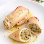 Calamari ripieni cotti e serviti su un piatto bianco con olio e prezzemolo