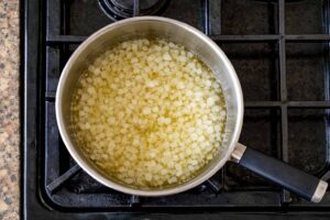 Cipolla che appassisce in padella per il risotto alla zucca