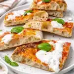 Pizza in teglia fatta in casa soffice dentro e croccante sotto, con pomodoro e mozzarella