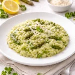 Risotto asparagi cremoso impiattato con punte di asparagi e Parmigiano
