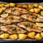 Pesce persico al forno in teglia con patate rosolate e limone, visto dall'alto