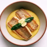 Pesce persico con polenta cremosa burro e salvia in ciotola rustica