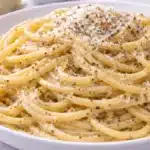 Cacio e pepe pasta con pecorino romano e pepe nero su piatto bianco
