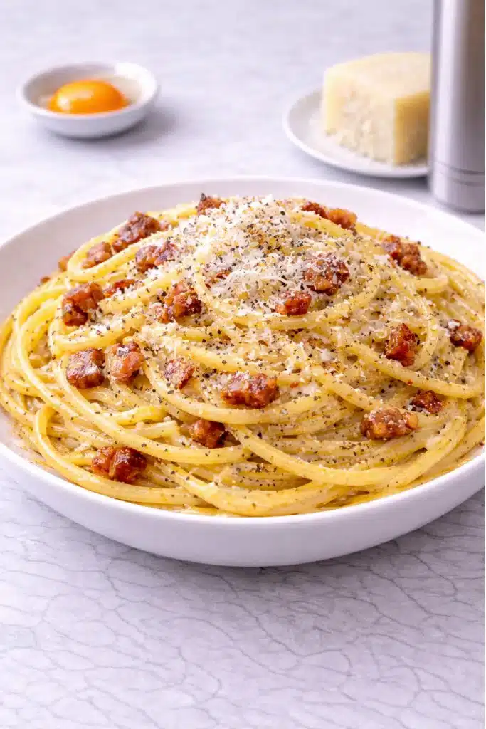 Pasta alla carbonara ricetta originale romana preparata con spaghetti, guanciale croccante, uova, pecorino romano e pepe nero. Un grande classico della cucina italiana.