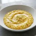 Mantecatura del risotto con consistenza cremosa e lucida all’onda ottenuta con burro e parmigiano